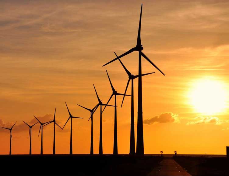 Wind turbines silhouetted at sunset